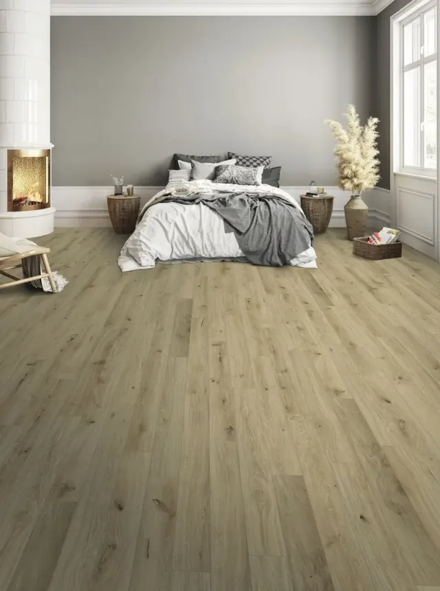 Cozy bedroom with a tile fireplace and warm wood-look flooring.