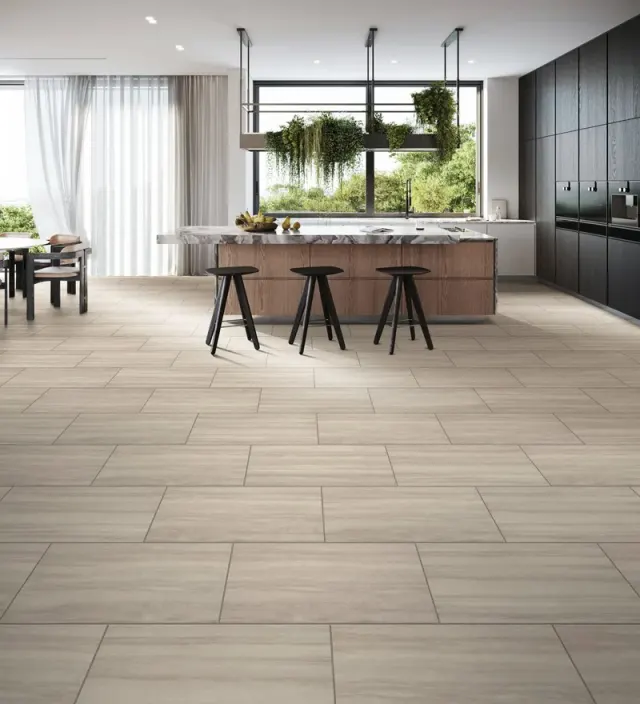 Modern kitchen with a marble island and large-format tile flooring.