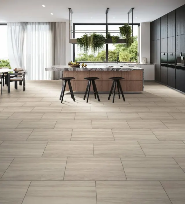 Modern kitchen with a marble island and large-format tile flooring.